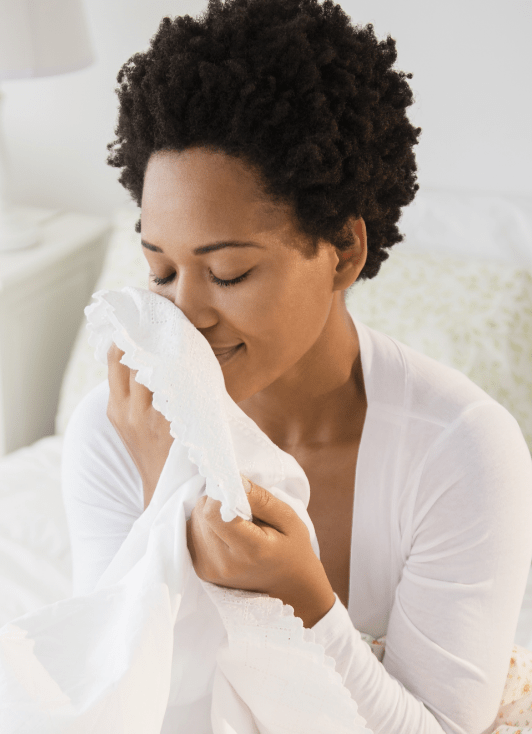A woman enjoying the scent of fresh, clean linen