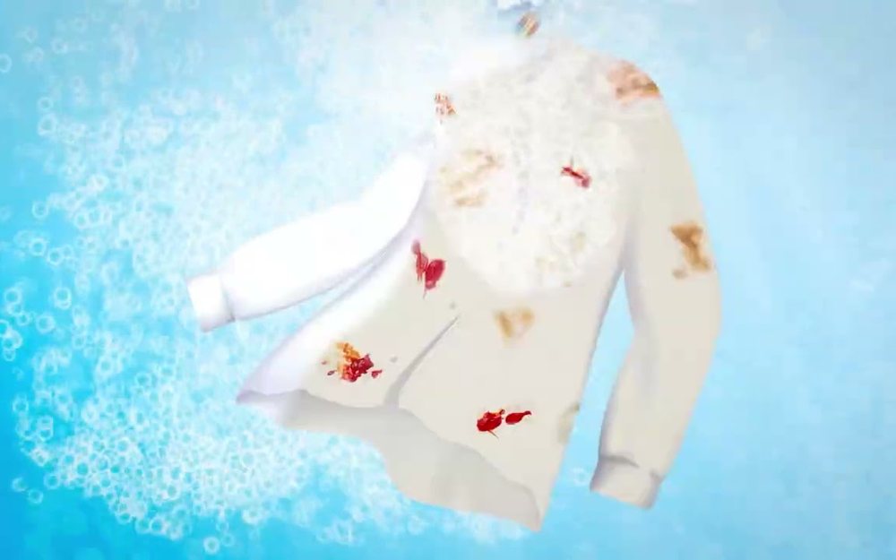 A stained white shirt suspended in blue water and foam, from the Too Clean Pro campaign film